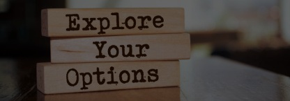 Three wooden blocks displaying the words ‘explore your options’ on a blurry background