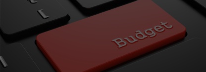 A close-up image of a red budget button on a black computer keyboard 