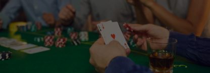 a mixed group of friends playing a friendly game of poker. One of the men is showing two aces.