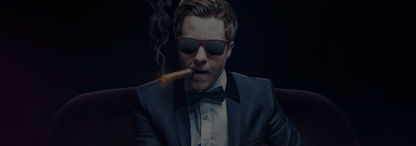 poker cliché of man in bow tie and suit wearing sunglasses smoking long cigar tossing poker chips in the air