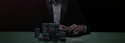 An image of a professional poker player sitting at a poker table with a massive chip stack