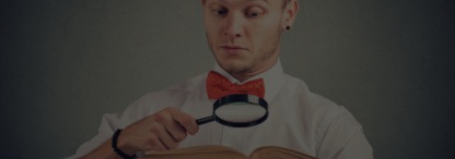An image of a young man reading an interesting story from a book with a magnifying glass against a greyish background