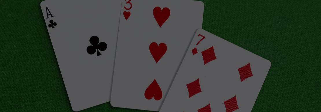 A - 3 - 7 playing cards showing face up on a green poker table