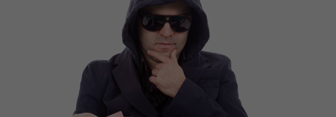 a guy with sunglasses and a hoodie at a poker table, thinking about his hand