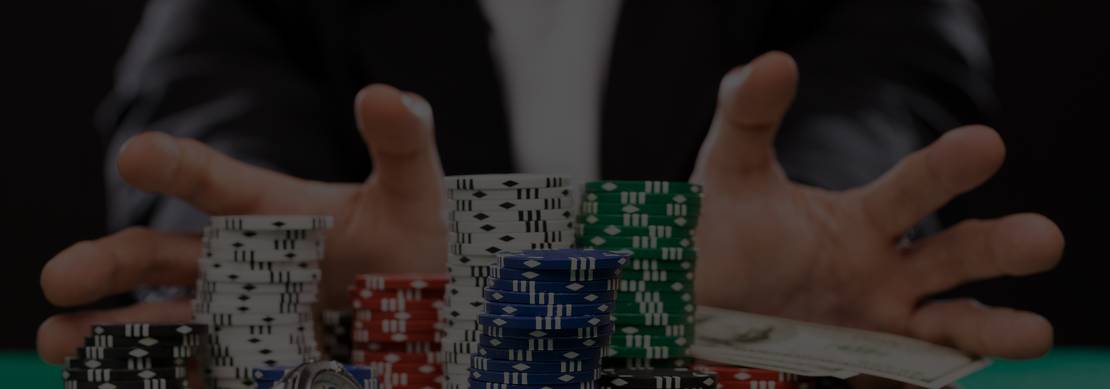 hands of a poker player pushing all his chips in to the pot