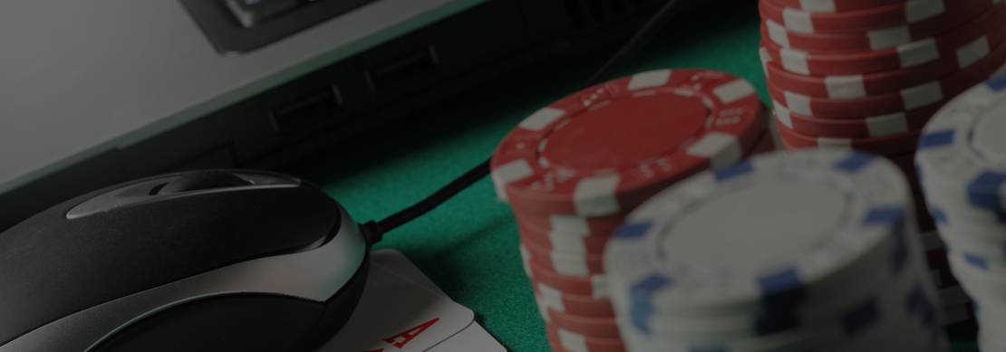 a laptop, mouse, poker chips and playing cards showing playing video poker at Juicy Stakes Casino