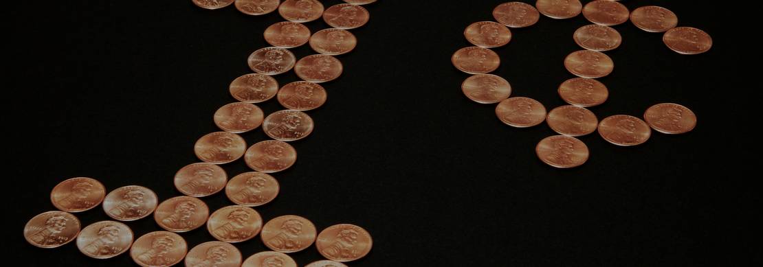 pennies laid out to read 1 cent on a black background
