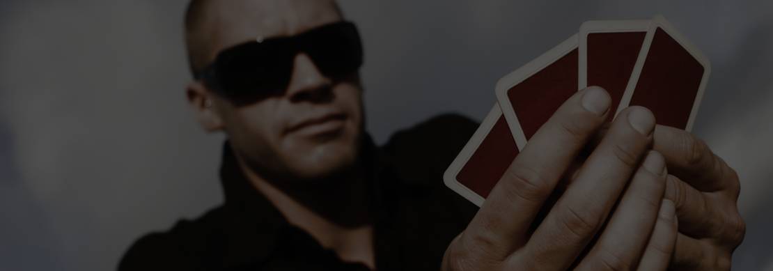 Poker player holding four cards with dark sunglasses on