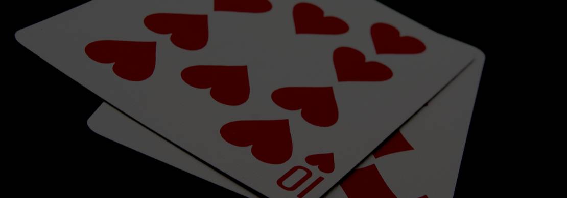 ten of hearts and ten of diamonds on a green poker table