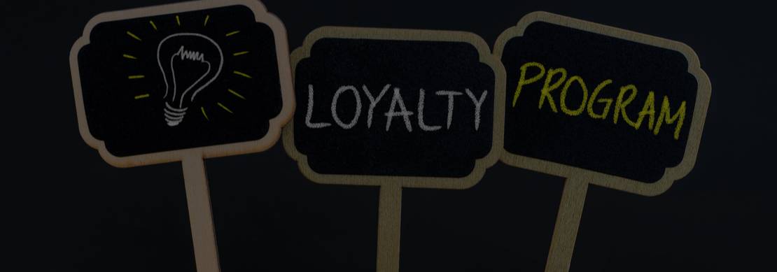 Three chalkboards with an image of a light bulb and the words ‘loyalty’ and ‘program’ on each