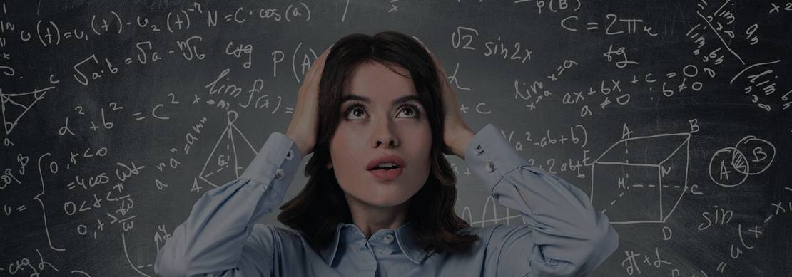 a confused woman holding her head standing in front of a chalkboard with mathematical figures all over it.