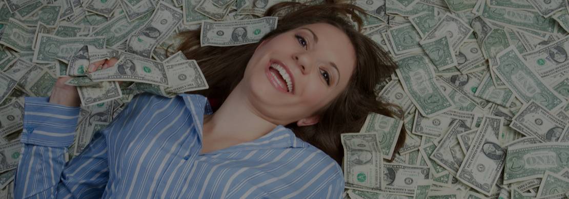 woman lying on a pile of cash dollar bills