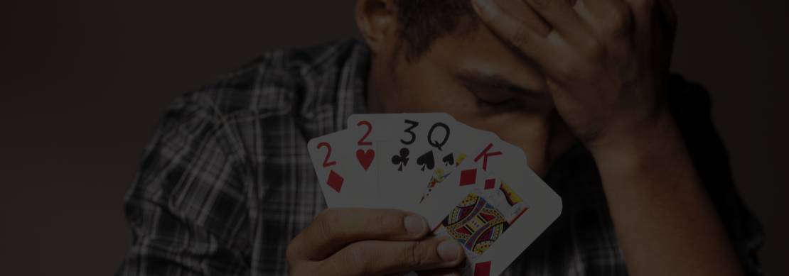 young poker player shows his sadness with a poor hand that he played because he was too impatient to wait for a better hand